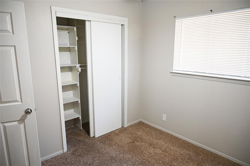 1352 Simpson Drive Hurst, TX 76053 - Photo 23 of 40 Interior space featuring light gray wall paint, brown carpet flooring, and a window with horizontal blinds