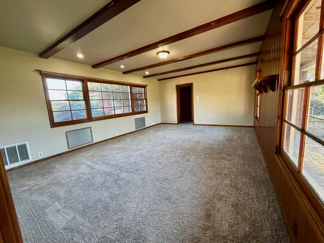 a view of an empty room with a fireplace and a window