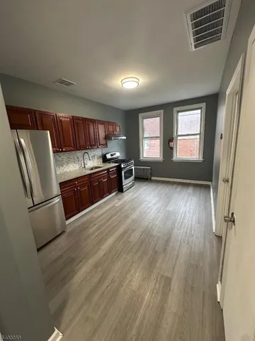 a kitchen with granite countertop wooden floors and stainless steel appliances