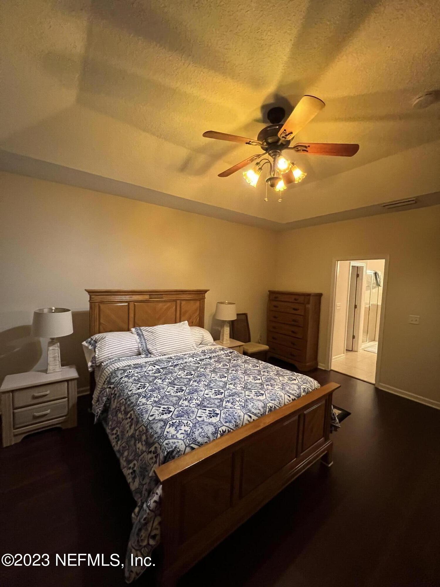 2406 Golfview Drive Fleming Island, FL 32003 - Photo 12 of 28 a bedroom with a bed and a chandelier