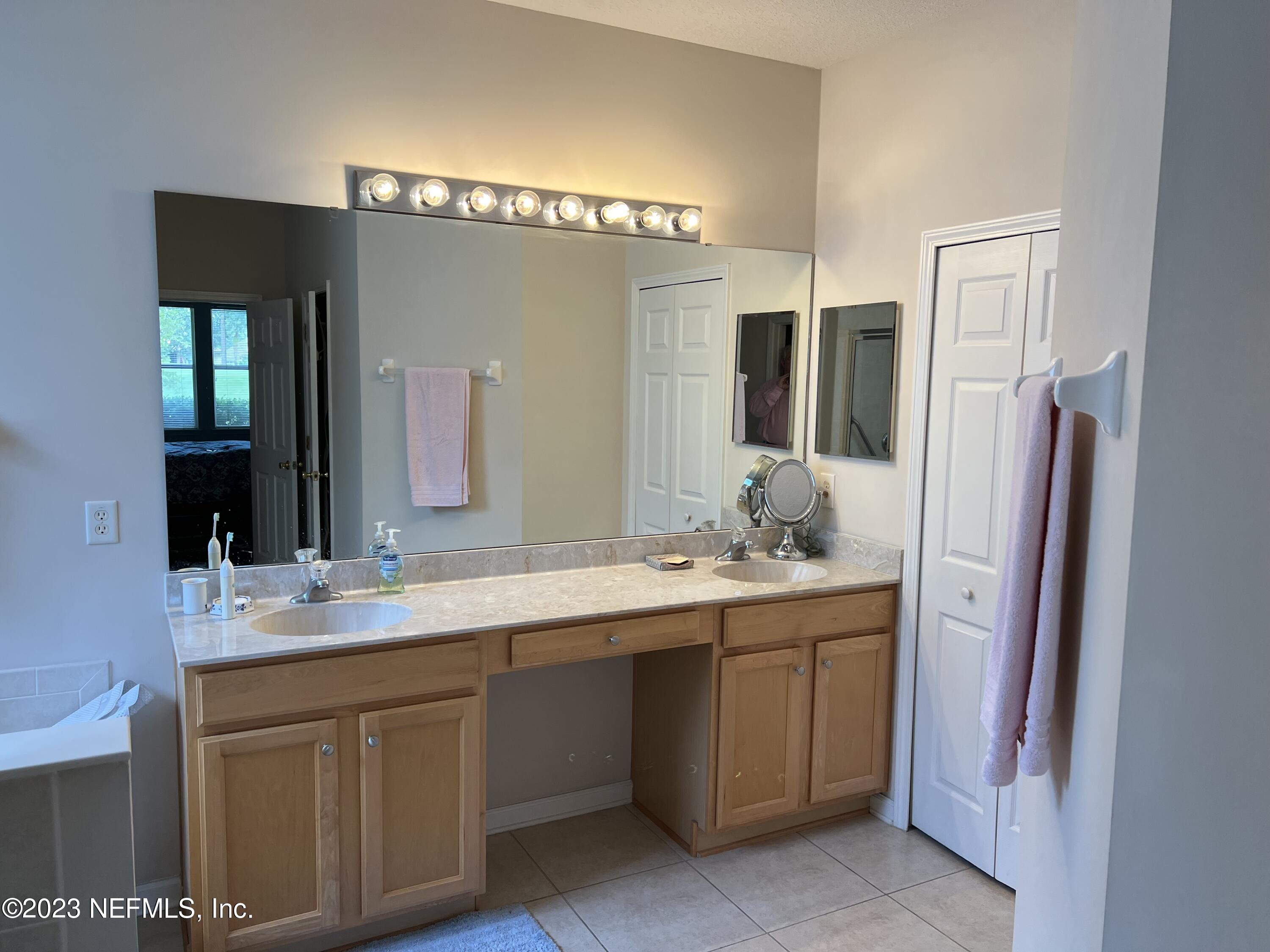 2406 Golfview Drive Fleming Island, FL 32003 - Photo 13 of 28 a bathroom with a double vanity sink and mirror