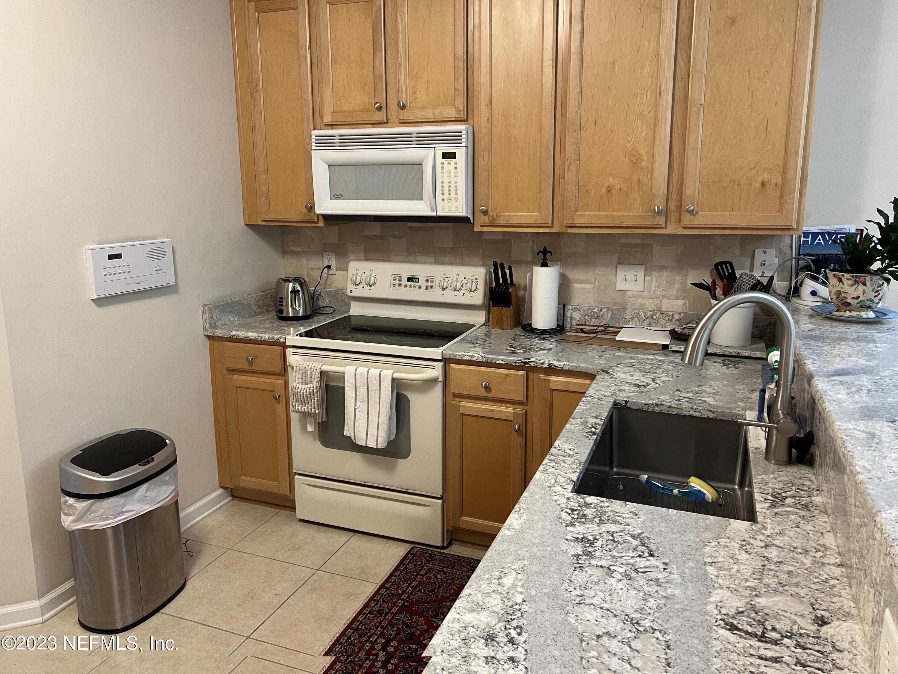 2406 Golfview Drive Fleming Island, FL 32003 - Photo 10 of 28 a kitchen with stainless steel appliances granite countertop a stove a sink and a microwave