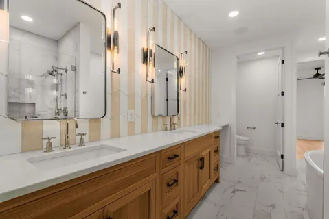 a spacious bathroom with a double vanity sink mirror double and shower