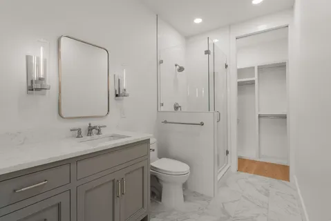 a bathroom with a toilet a sink a mirror and vanity