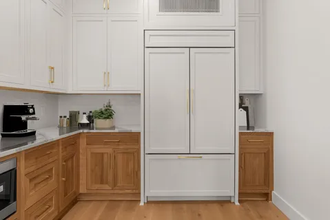 a kitchen with a refrigerator white cabinets and white appliances