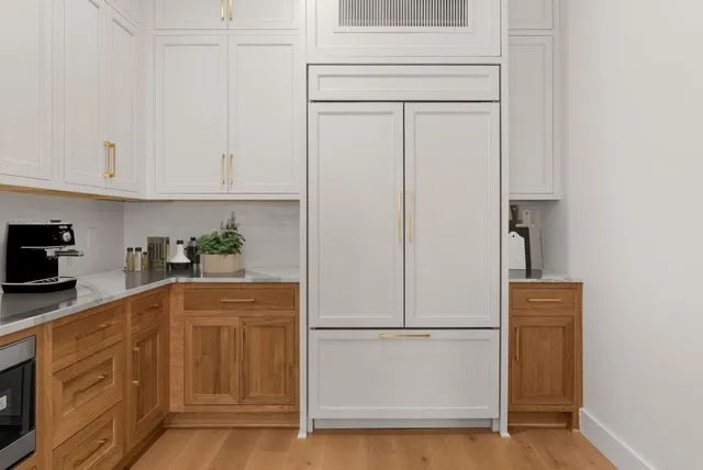 a kitchen with a refrigerator white cabinets and white appliances
