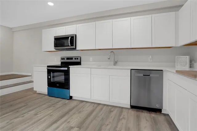 a kitchen with stainless steel appliances granite countertop a stove a sink and a microwave