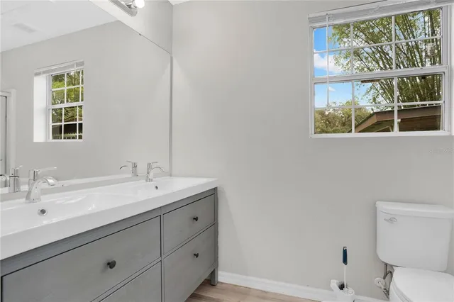 a bathroom with a sink a toilet and a window