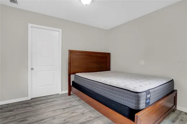 a bedroom with a bed and wooden floor