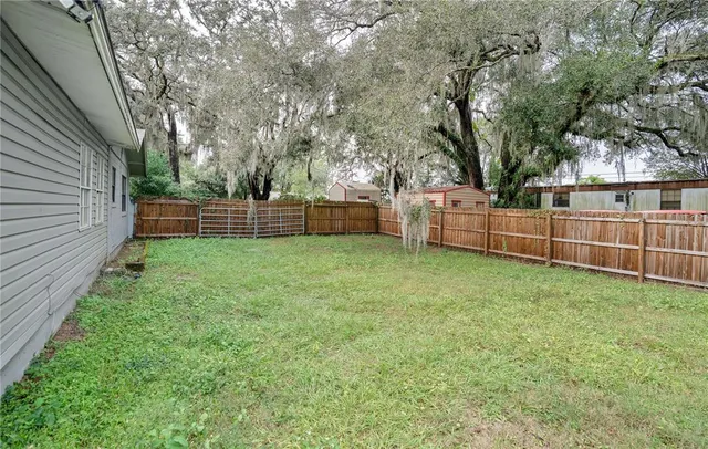 a view of a backyard with a wooden fence