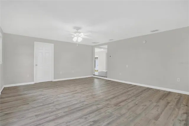 a view of an empty room with wooden floor