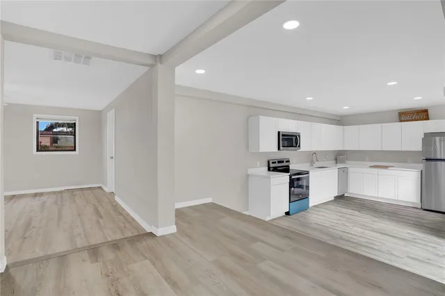 a kitchen with a refrigerator and a stove top oven