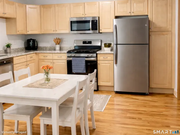 a kitchen with stainless steel appliances granite countertop a refrigerator a stove a sink a microwave and white cabinets