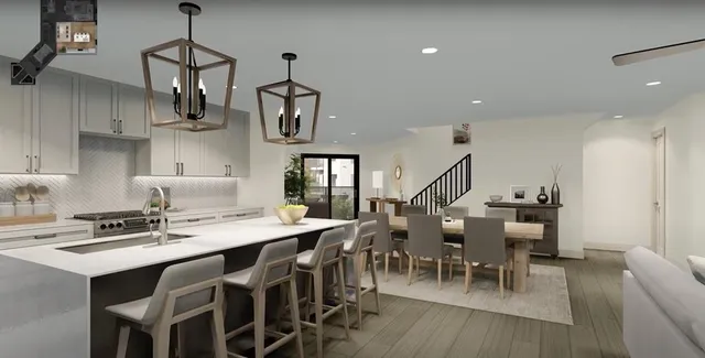 a kitchen with stainless steel appliances granite countertop a dining table chairs stove and white cabinets