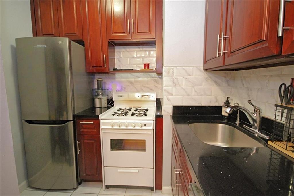 7259 Shore Road, Unit 5A Brooklyn, NY 11209 - Photo 15 of 18 a kitchen with a refrigerator sink and cabinets
