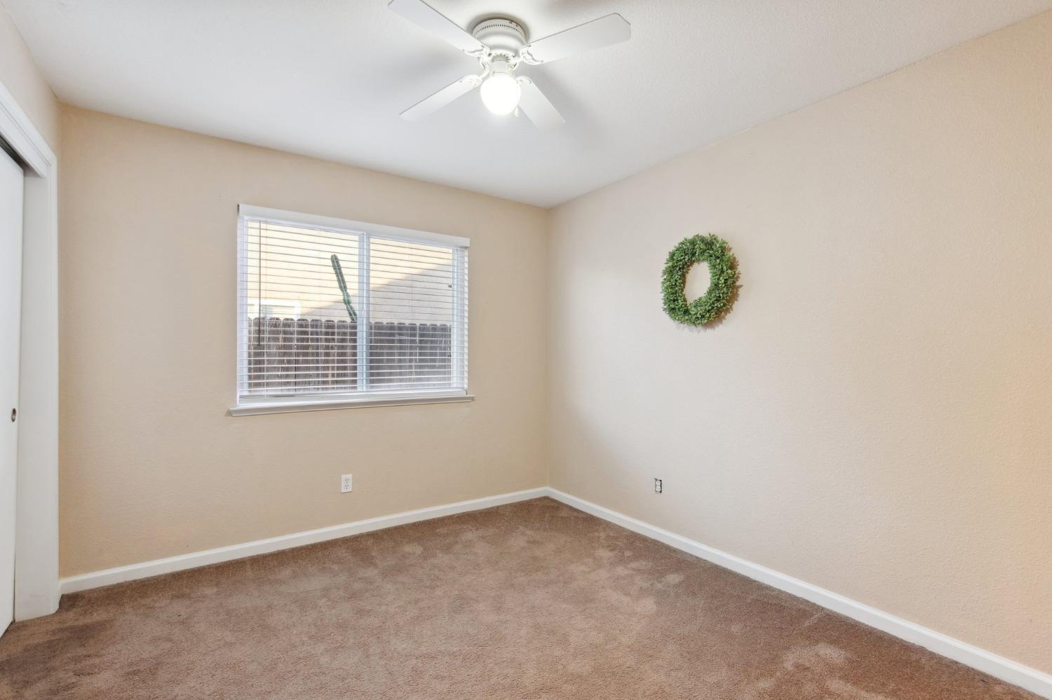 257 Toschi Drive Madera, CA 93637 - Photo 18 of 40 an empty room with a window and ceiling fan