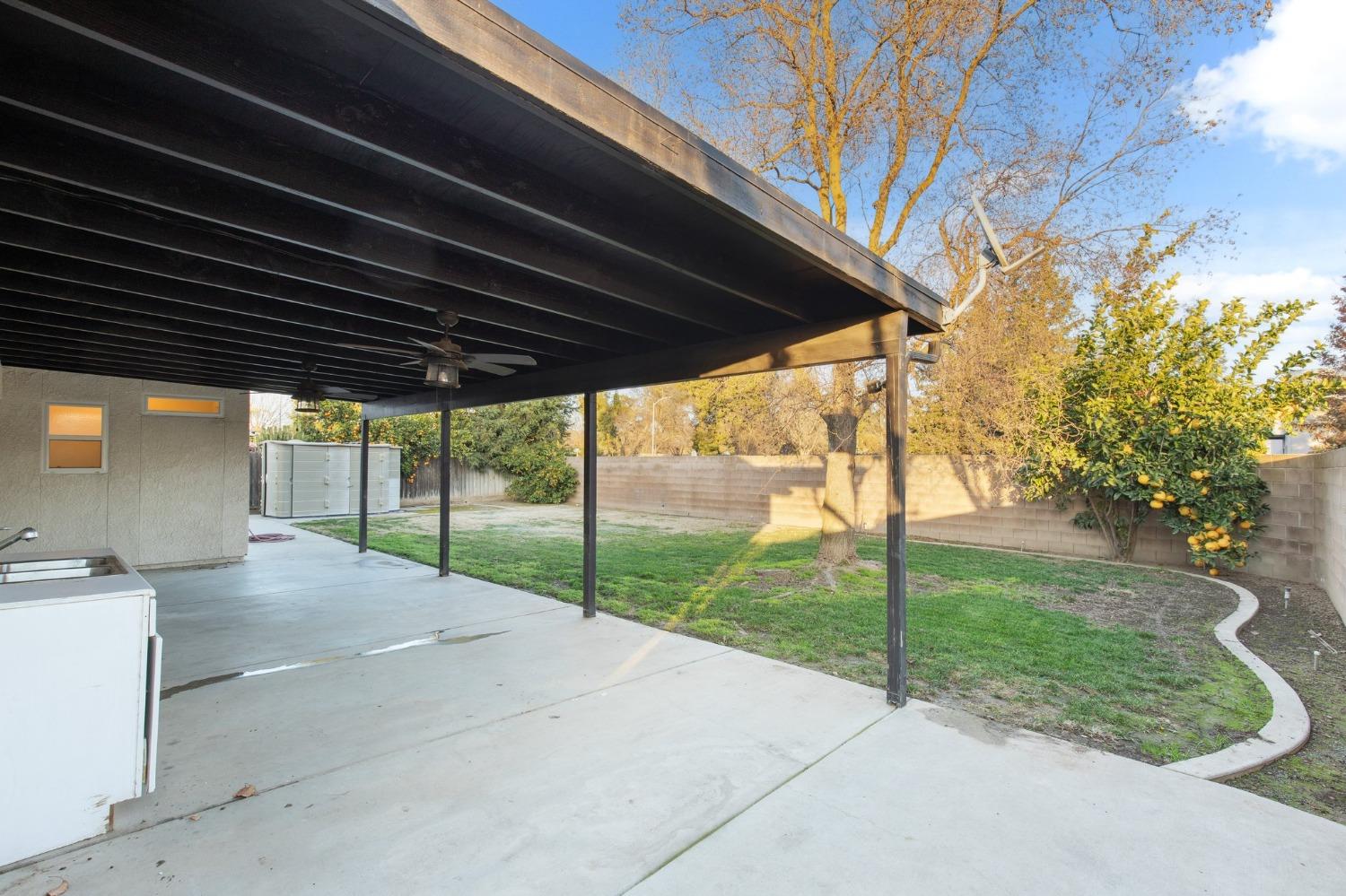 257 Toschi Drive Madera, CA 93637 - Photo 22 of 40 a view of a backyard with floor to ceiling window and a yard