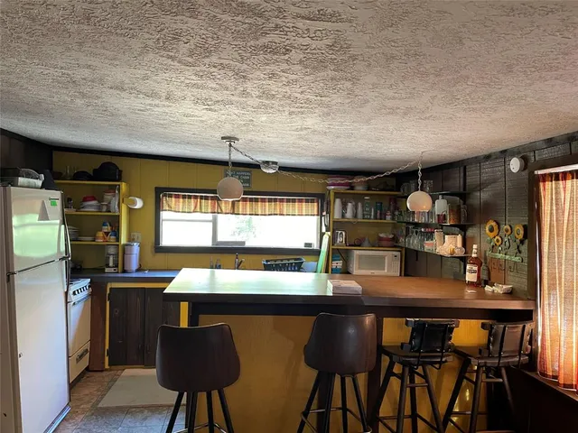 a kitchen with stainless steel appliances a table and chairs in it