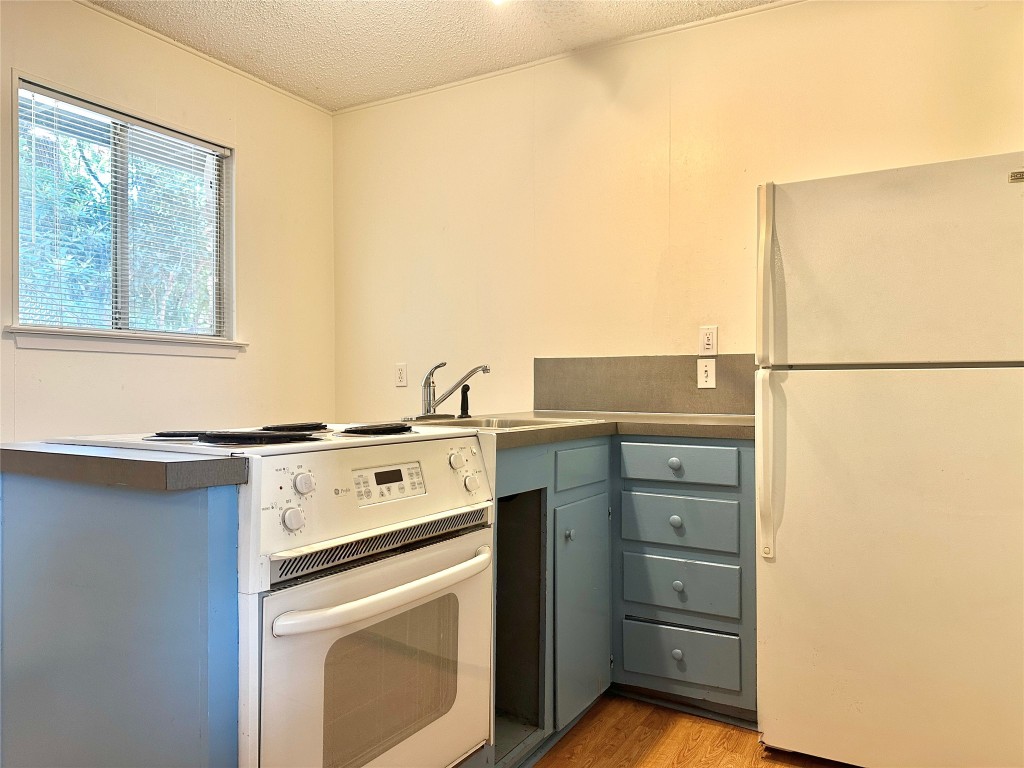 2711 Hemphill Park, Unit A Austin, TX 78705 - Photo 5 of 8 a kitchen with a stove and a white refrigerator