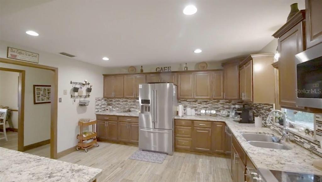 2700 Southeast 157th Lane Road Summerfield, FL 34491 - Photo 11 of 13 a kitchen with stainless steel appliances granite countertop a sink stove and refrigerator