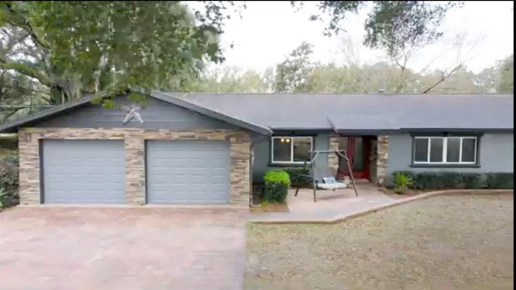 2700 Southeast 157th Lane Road Summerfield, FL 34491 - Photo 9 of 13 a front view of a house with garden and patio