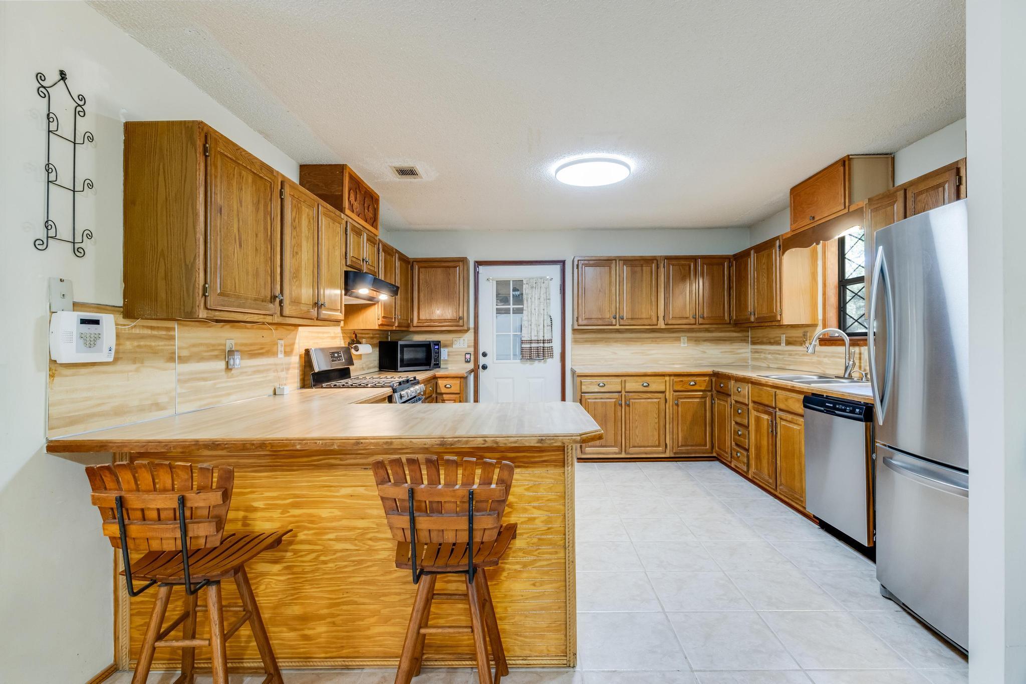 6359 Shangri La Road Crestview, FL 32539 - Photo 11 of 56 a view of a kitchen with kitchen island a counter top space a sink stainless steel appliances and cabinets