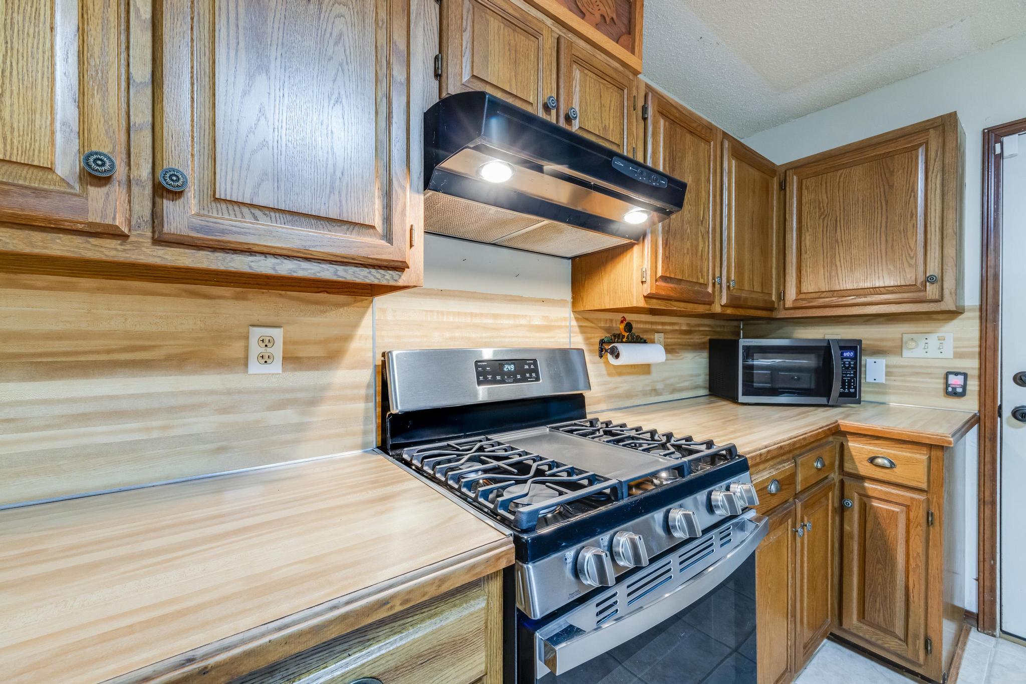 6359 Shangri La Road Crestview, FL 32539 - Photo 14 of 56 a kitchen with stainless steel appliances granite countertop a stove and a microwave