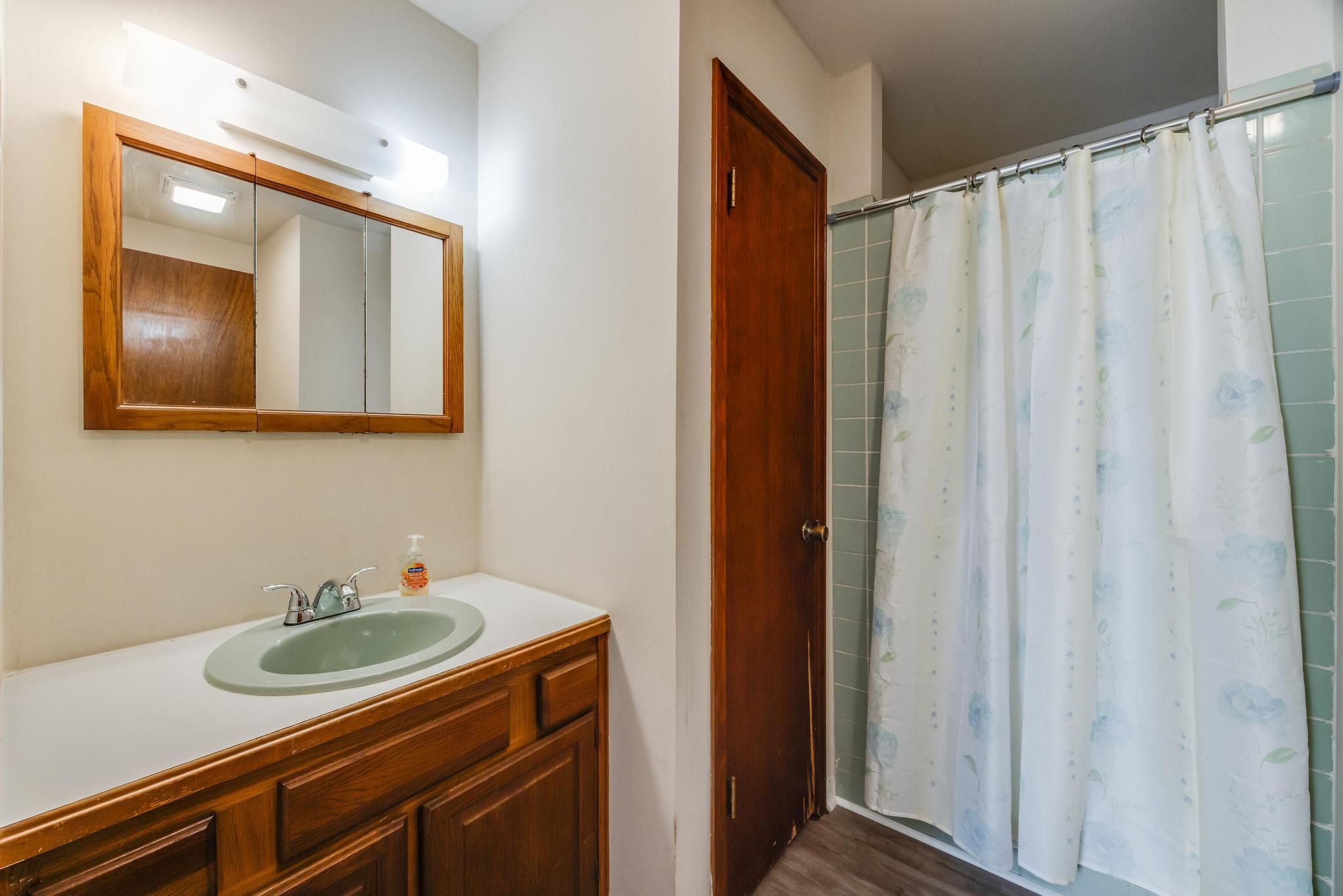 6359 Shangri La Road Crestview, FL 32539 - Photo 28 of 56 a bathroom with a sink a mirror and a shower curtain