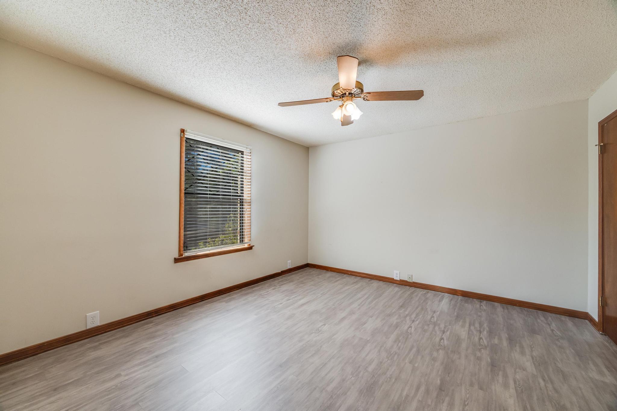6359 Shangri La Road Crestview, FL 32539 - Photo 31 of 56 an empty room with wooden floor chandelier fan and windows