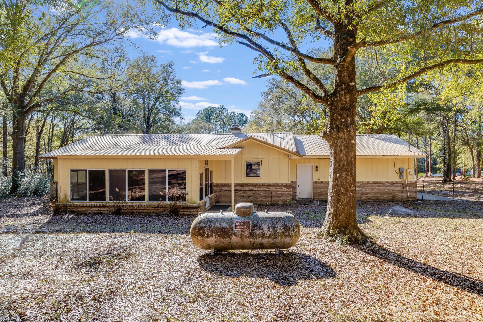 6359 Shangri La Road Crestview, FL 32539 - Photo 38 of 56 a front view of a house with a yard and trees