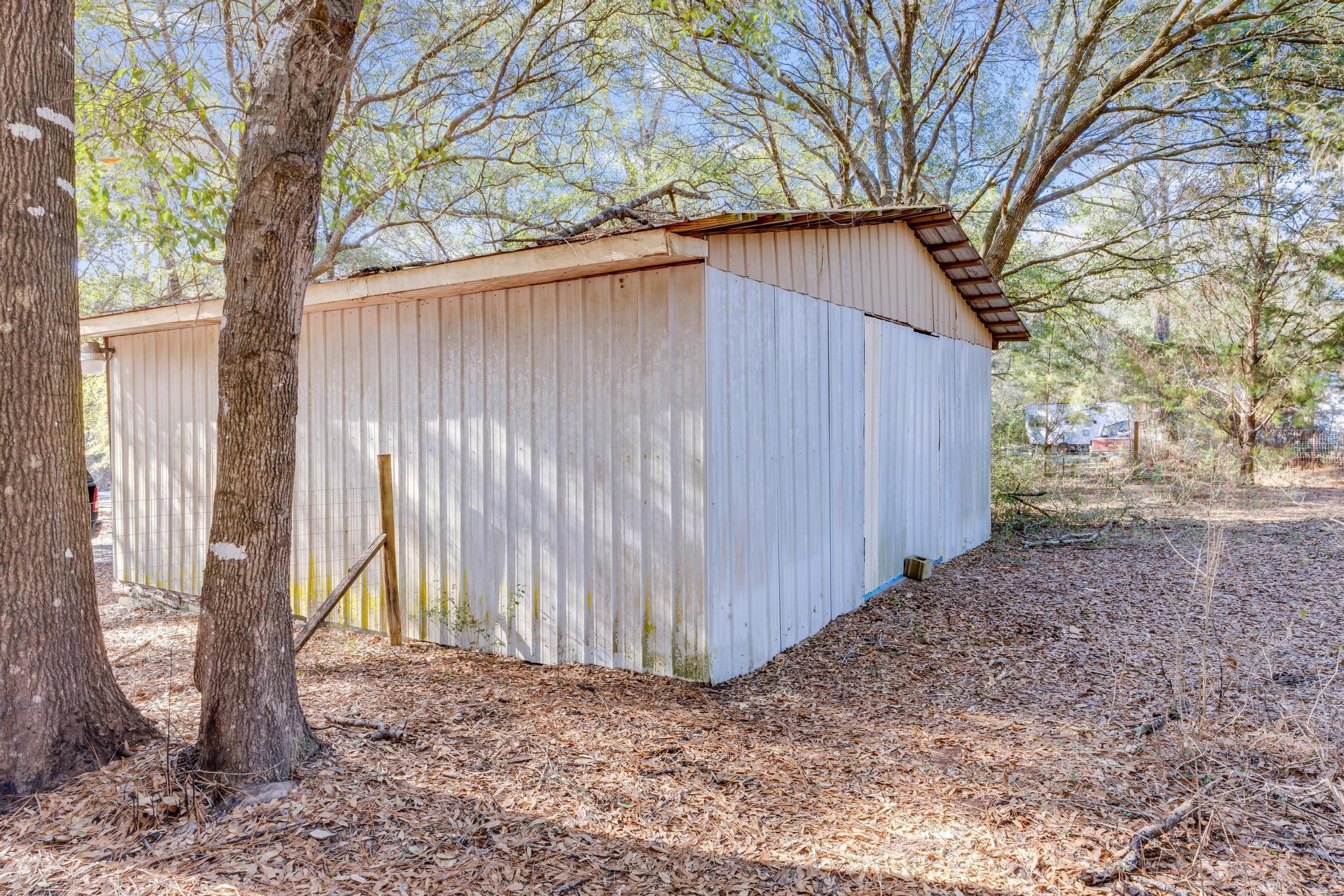 6359 Shangri La Road Crestview, FL 32539 - Photo 49 of 56 a backyard of a house with large trees and wooden fence