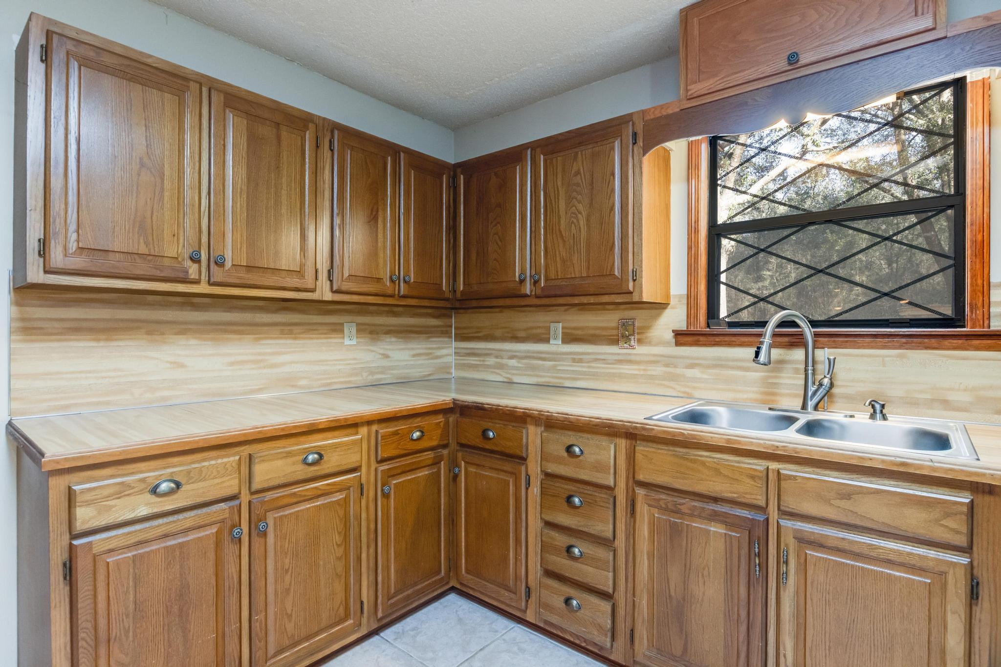 6359 Shangri La Road Crestview, FL 32539 - Photo 8 of 56 a kitchen with stainless steel appliances granite countertop a sink and cabinets with wooden floor