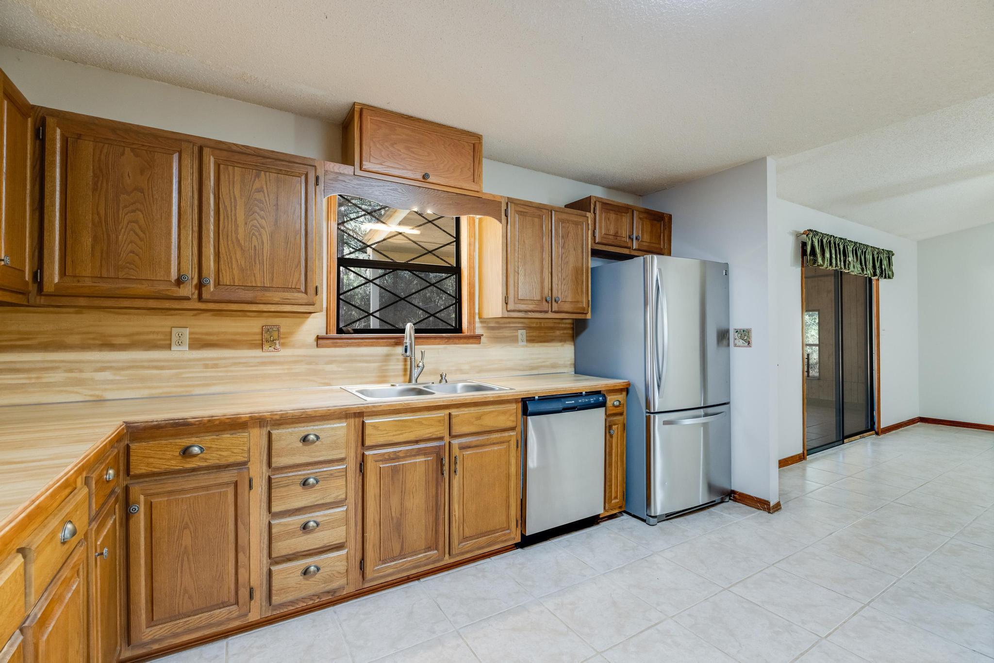 6359 Shangri La Road Crestview, FL 32539 - Photo 9 of 56 a kitchen with stainless steel appliances granite countertop a refrigerator sink and cabinets