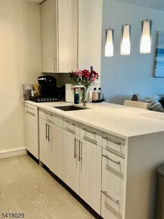 a kitchen with white cabinets and sink