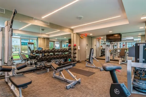 a room with gym equipment and large mirror