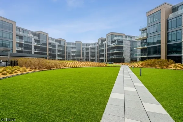 a view of a big building with a big yard and large trees