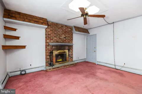 a view of empty room with fireplace and fan