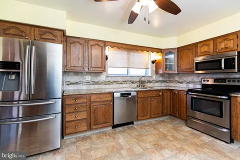 a kitchen with granite countertop stainless steel appliances and wooden cabinets