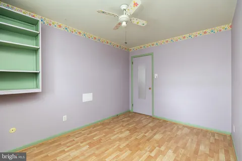 a view of a room with a ceiling fan and hardwood floor