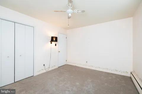 an empty room with chandelier fan