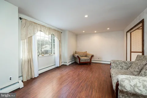 a living room with furniture and a wooden floor