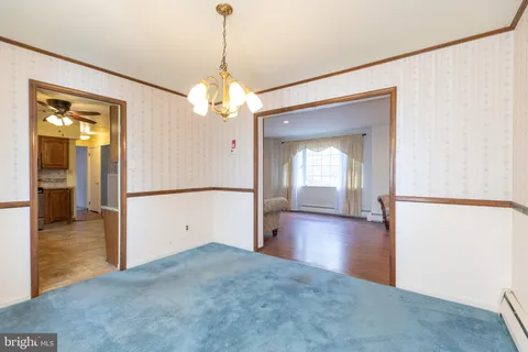 a view of a livingroom with a chandelier fan and wooden floor