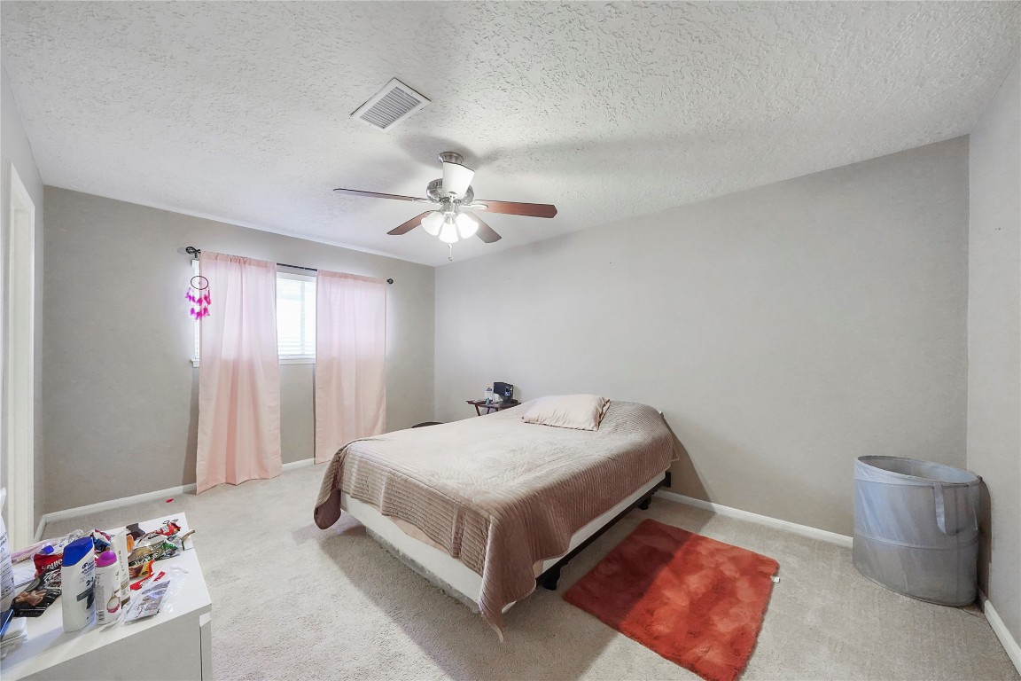 14607 Muirfield Lane Houston, TX 77095 - Photo 19 of 33 a spacious bedroom with a bed and a chandelier