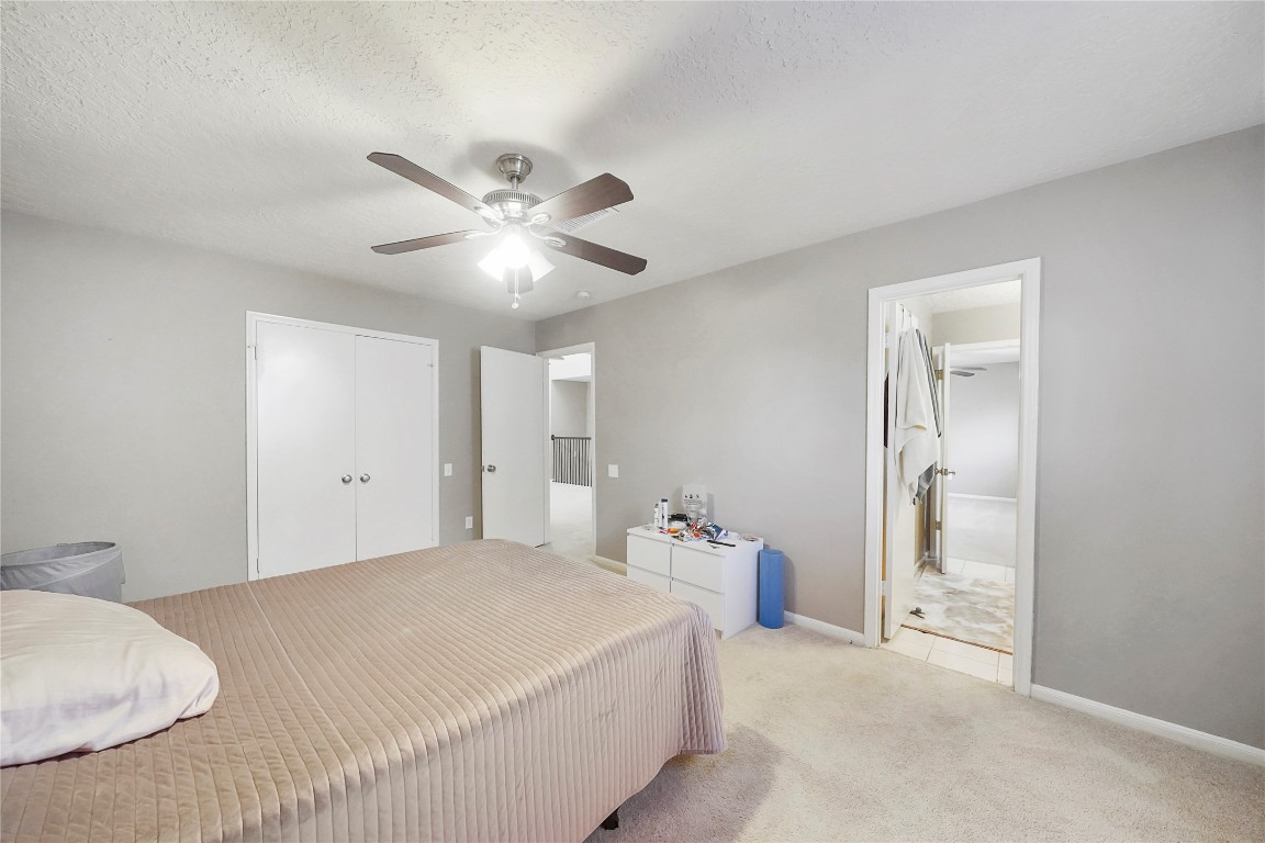 14607 Muirfield Lane Houston, TX 77095 - Photo 20 of 33 a bedroom with a bed and a chandelier