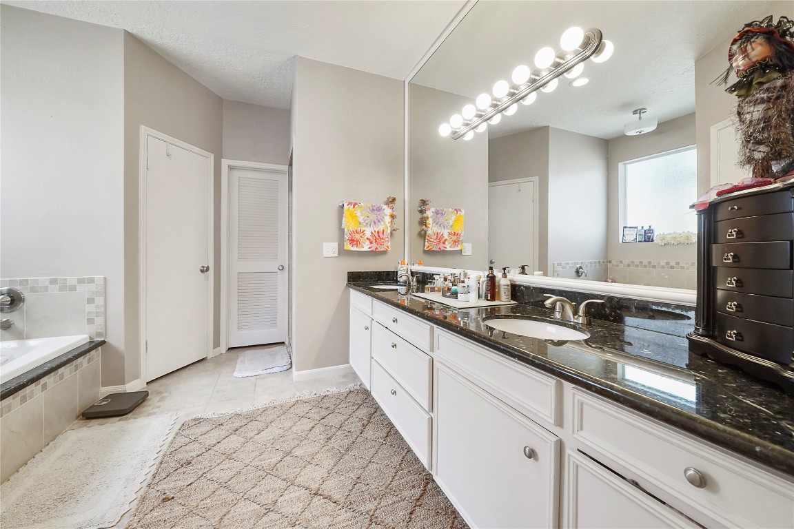14607 Muirfield Lane Houston, TX 77095 - Photo 7 of 33 a spacious en suite bathroom with double vanity and a mirror