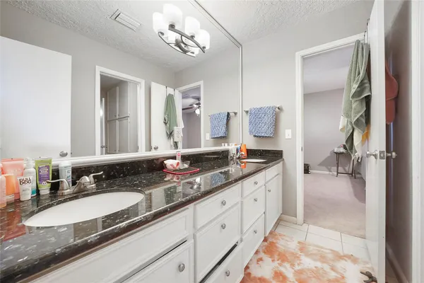 a bathroom with double vanity sinks a vanity a mirror and a shower