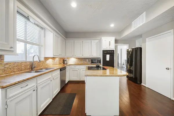 a kitchen with a sink a refrigerator and cabinets