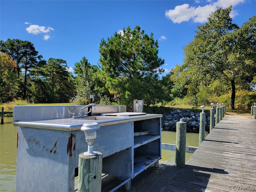 405 Locklies Creek Road Topping, VA 23169 - Photo 13 of 30 a view of a patio with table and chairs with wooden floor and fence