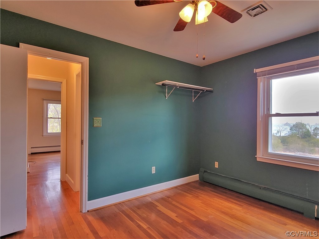 405 Locklies Creek Road Topping, VA 23169 - Photo 26 of 30 a view of an empty room with window and wooden floor