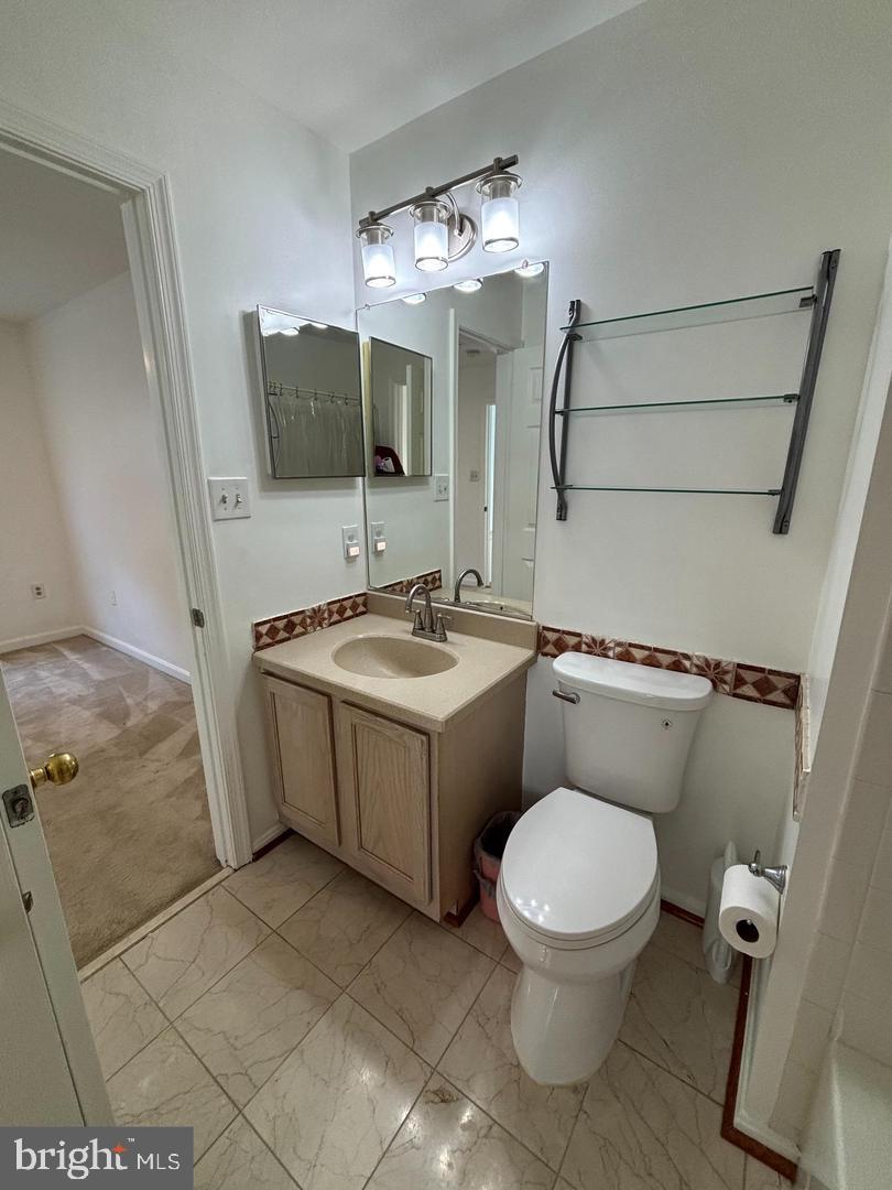 22985 Fleet Terrace Sterling, VA 20166 - Photo 14 of 14 a bathroom with a toilet sink and mirror